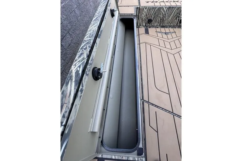 Slide: The Image of 2026 Tracker Grizzly 1756 T Marsh boat interior storage compartment, camo design. - 12