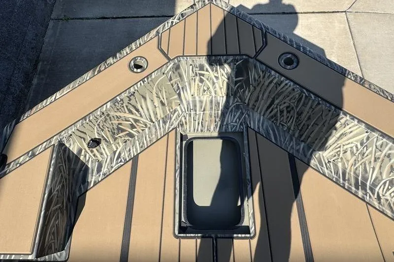 Slide: The Image of 2026 Tracker Grizzly 1756 T Marsh boat deck with camouflage pattern and storage compartment. - 13