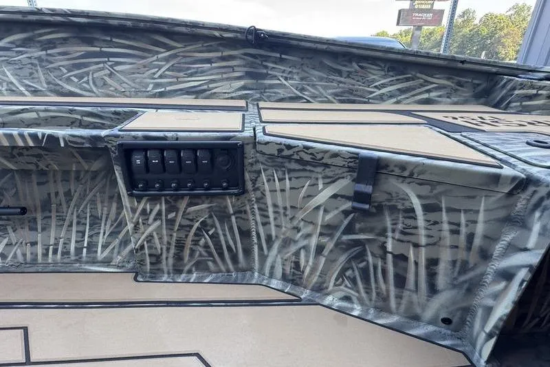 Slide: The Image of 2026 Tracker Grizzly 1756 T Marsh boat interior with camo design and control panel. - 6