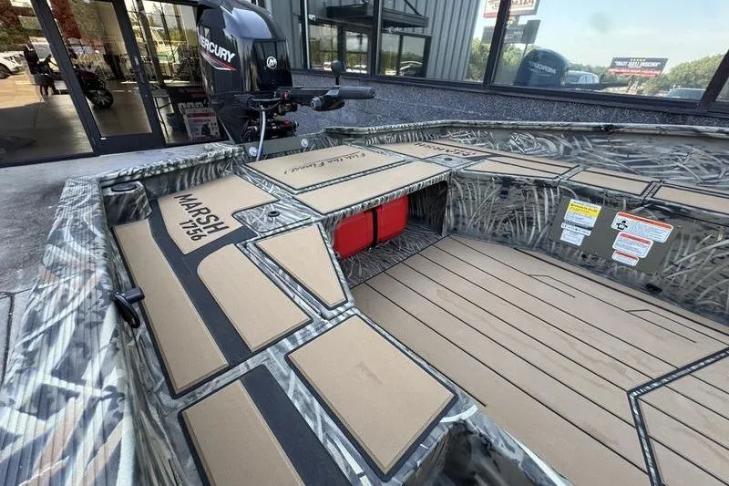 Slide: The Image of 2026 Tracker Grizzly 1756 T Marsh boat interior with camo design and Mercury engine. - 9