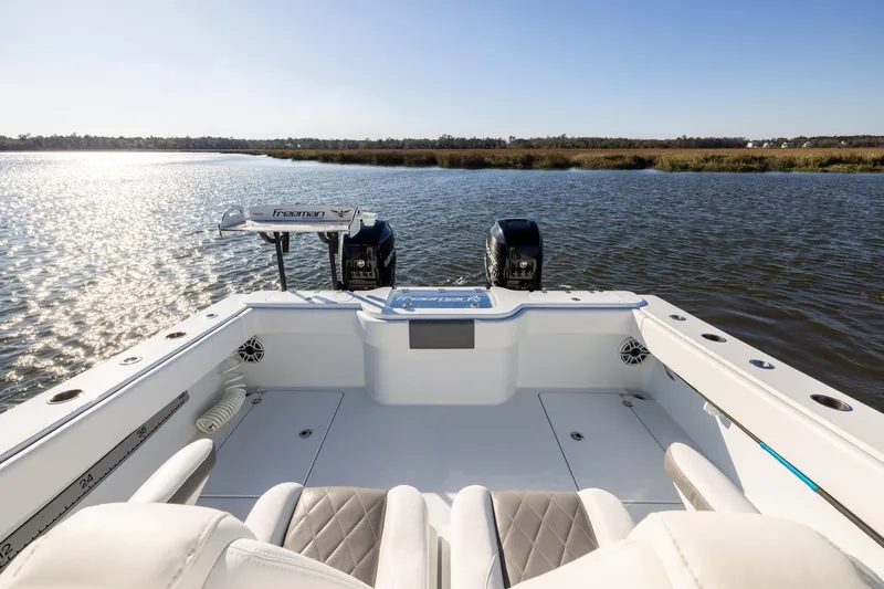 Slide: The Image of 2023 Freeman 34VH boat on serene water, featuring dual engines and spacious seating. - 18