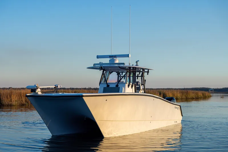 Slide: The Image of 2023 Freeman 34VH boat on calm water at sunset, showcasing sleek design. - 3