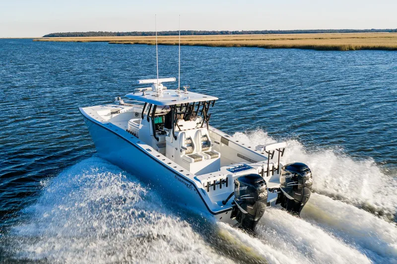 Slide: The Image of 2023 Freeman 34VH boat cruising on open water with twin Mercury engines. - 5