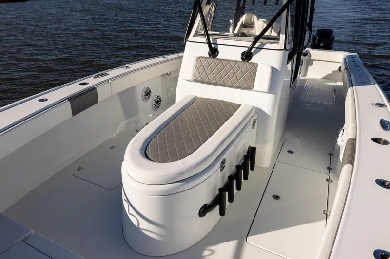 Slide: The Image of 2023 Freeman 34VH boat interior with cushioned seating and rod holders on the water. - 9