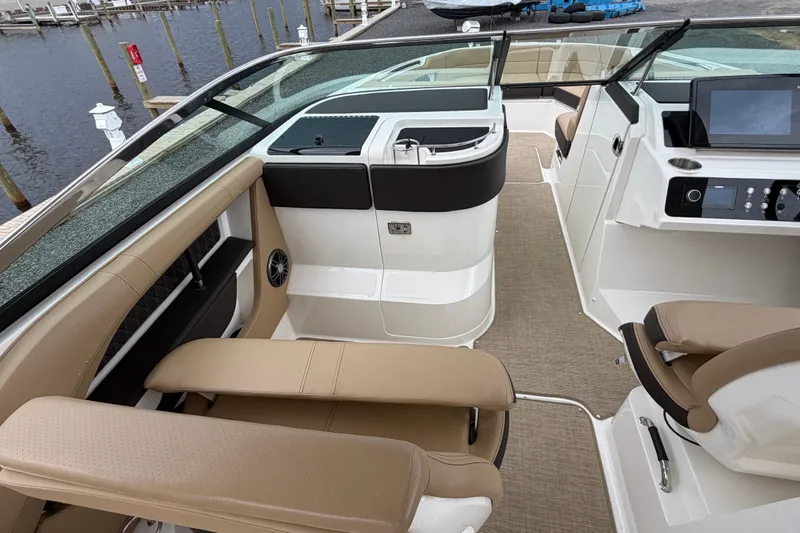 Slide: The Image of 2023 Sea Ray SLX 310 Outboard interior with beige seating and modern dashboard. - 14