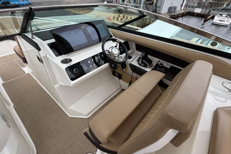 Slide: The Image of 2023 Sea Ray SLX 310 Outboard helm with modern controls and luxurious seating. - 16