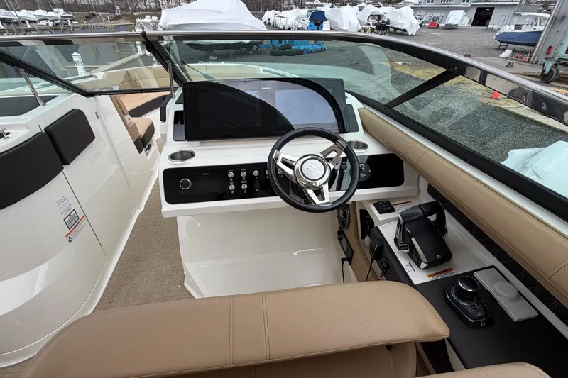 Slide: The Image of 2023 Sea Ray SLX 310 Outboard helm with modern controls and beige seating. - 18
