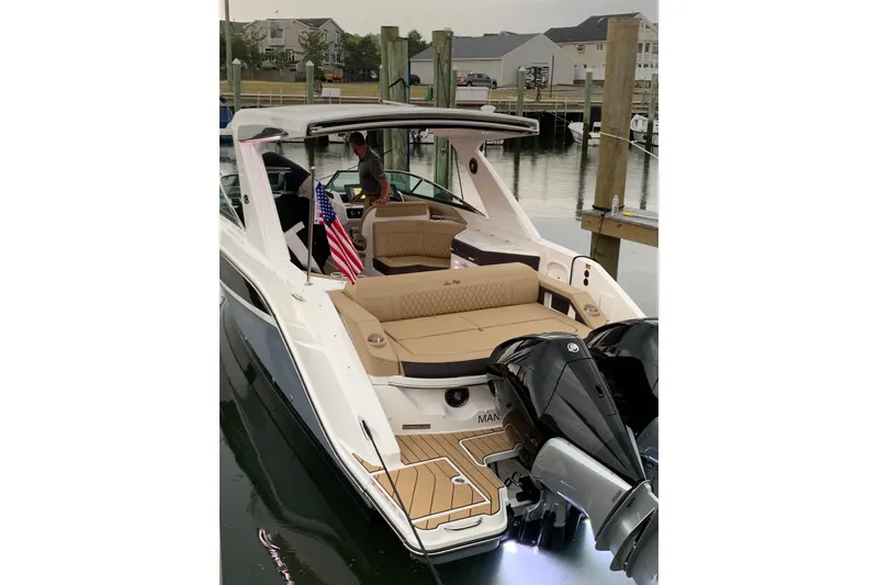 Slide: The Image of 2023 Sea Ray SLX 310 Outboard docked, featuring luxurious seating and dual outboard engines. - 6