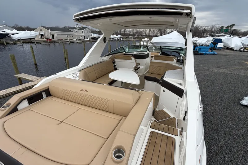 Slide: The Image of 2023 Sea Ray SLX 310 Outboard boat with luxurious seating and sleek design at a marina. - 9