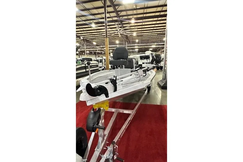 Slide: The Image of 2025 Xpress H22B Bay boat on display in a showroom with red carpet. - 2