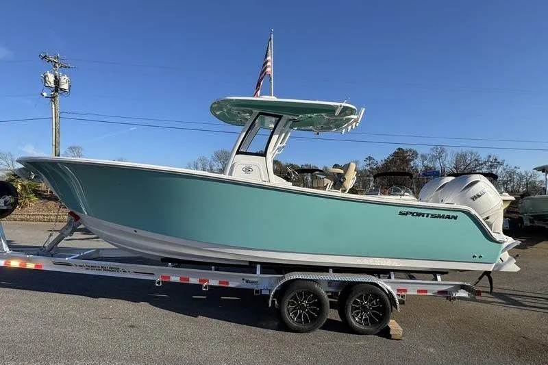 Slide: The Image of 2026 Sportsman Open 252 Center Console boat on trailer, teal hull, sunny day. - 25