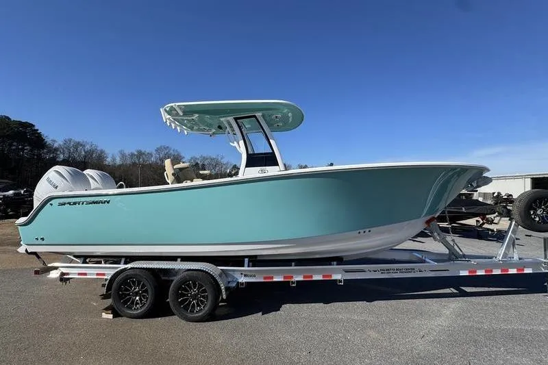 Slide: The Image of 2026 Sportsman Open 252 Center Console boat on trailer, teal hull, clear sky background. - 30