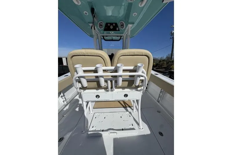 Slide: The Image of 2026 Sportsman Open 252 Center Console boat interior with beige seating and rod holders. - 31