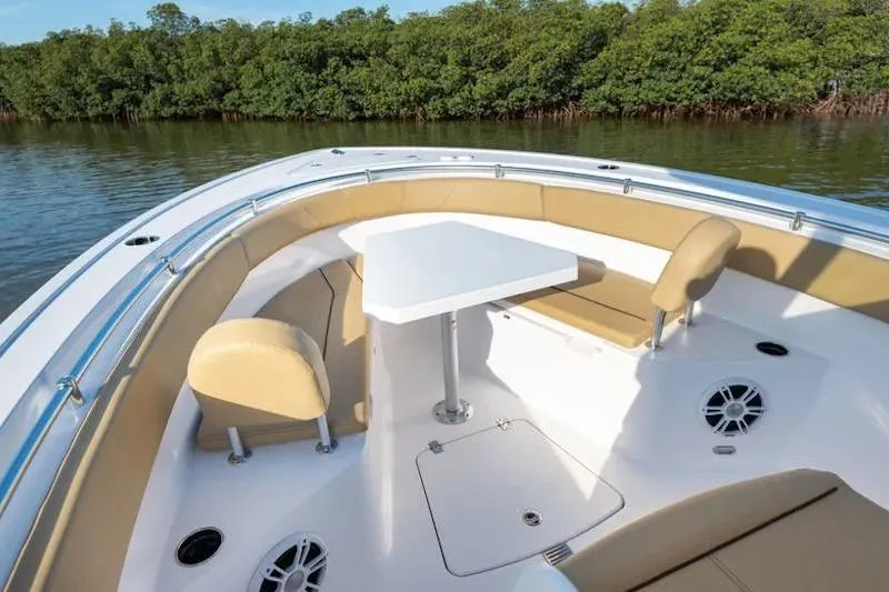 Slide: The Image of 2026 Sportsman Open 252 Center Console boat with seating and table, surrounded by water and greenery. - 36