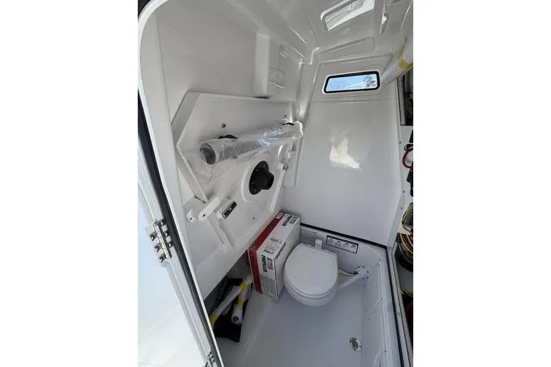 Slide: The Image of Interior of 2026 Sportsman Open 252 Center Console boat, featuring compact restroom facilities. - 7