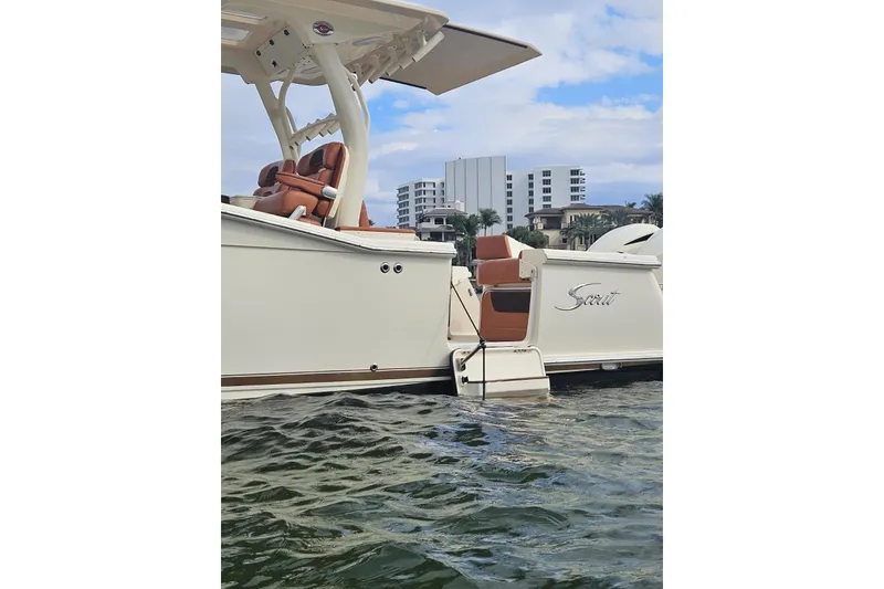 Slide: The Image of 2015 Scout 350 LXF boat on water with cityscape background. - 14