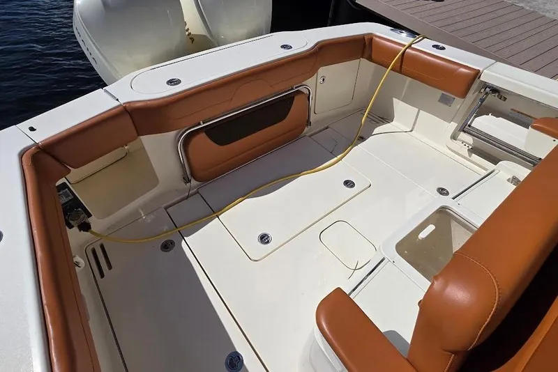 Slide: The Image of 2015 Scout 350 LXF boat deck with tan seating and storage compartments. - 24
