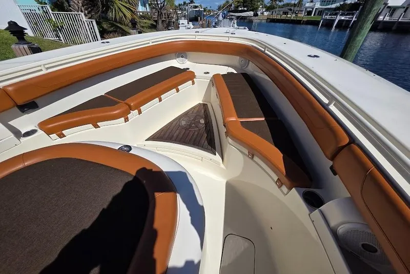 Slide: The Image of 2015 Scout 350 LXF boat interior with brown cushioned seating and wooden flooring. - 30