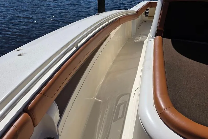 Slide: The Image of 2015 Scout 350 LXF boat deck with brown trim, near water. - 33