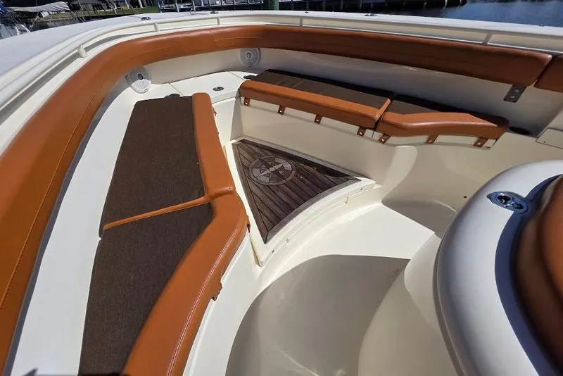 Slide: The Image of 2015 Scout 350 LXF boat interior with brown cushioned seating and wooden flooring. - 34