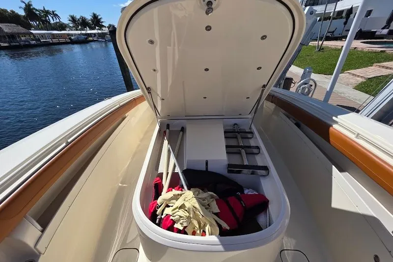 Slide: The Image of Open storage compartment on 2015 Scout 350 LXF boat, docked by waterfront. - 38