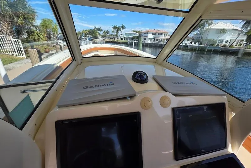 Slide: The Image of Helm of 2015 Scout 350 LXF boat with Garmin navigation system, docked by waterfront homes. - 43