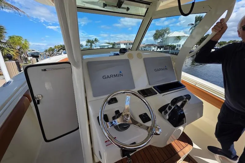 Slide: The Image of 2015 Scout 350 LXF boat helm with Garmin displays and steering wheel. - 47