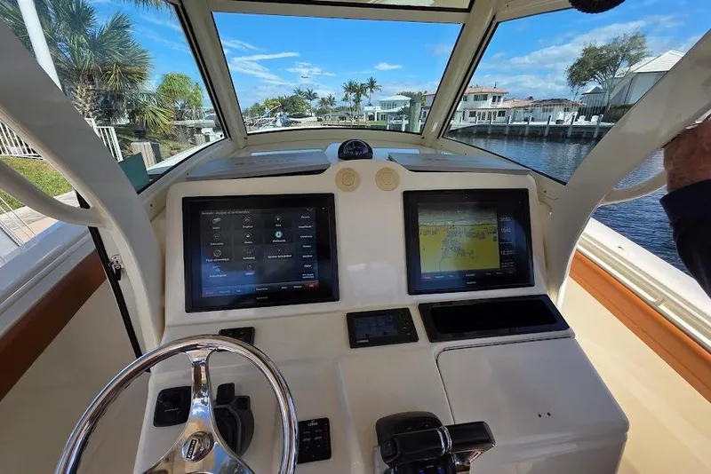 Slide: The Image of Helm of 2015 Scout 350 LXF boat with dual navigation screens and steering wheel. - 48