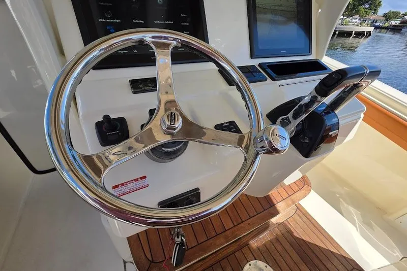 Slide: The Image of Steering wheel and controls of a 2015 Scout 350 LXF boat. - 49