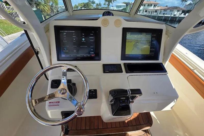 Slide: The Image of 2015 Scout 350 LXF boat dashboard with dual screens and steering wheel. - 50