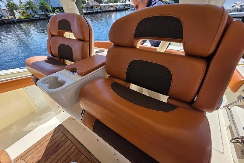 Slide: The Image of Luxurious leather seating on 2015 Scout 350 LXF boat, featuring cup holders and waterfront view. - 62