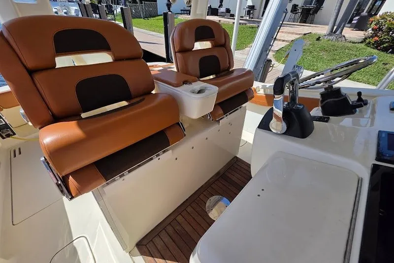 Slide: The Image of 2015 Scout 350 LXF boat interior with brown leather seats and steering console. - 65