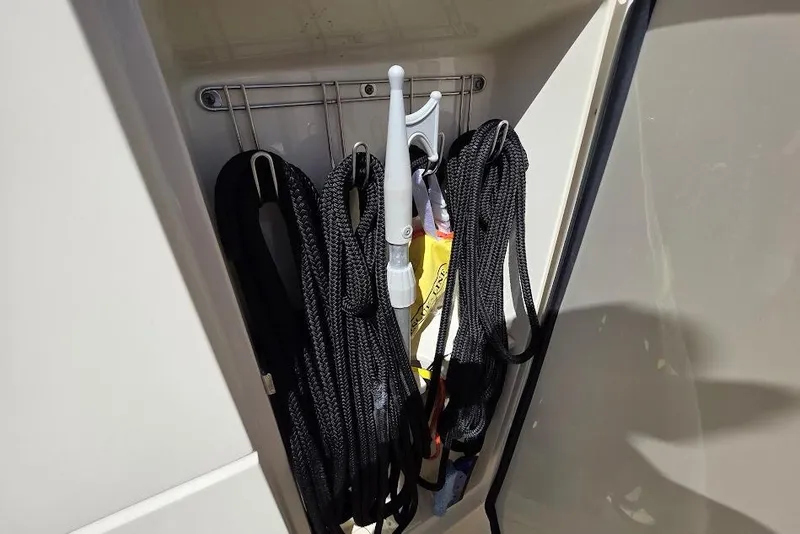 Slide: The Image of Storage compartment with ropes and tools on a 2015 Scout 350 LXF boat. - 79