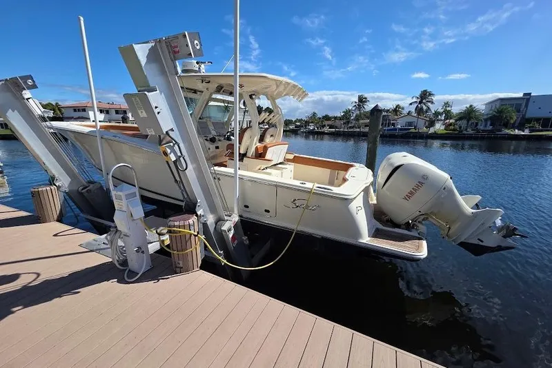 Slide: The Image of 2015 Scout 350 LXF boat docked with Yamaha engine, under clear blue sky. - 8