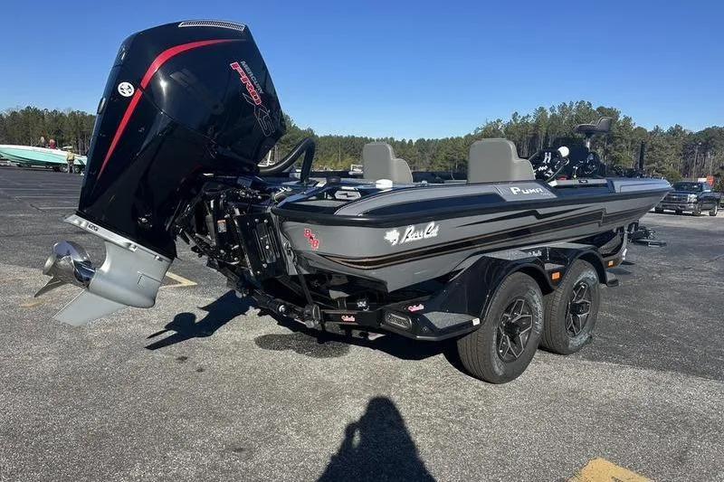 Slide: The Image of 2026 Bass Cat Puma STS boat on trailer, parked outdoors under clear sky. - 2