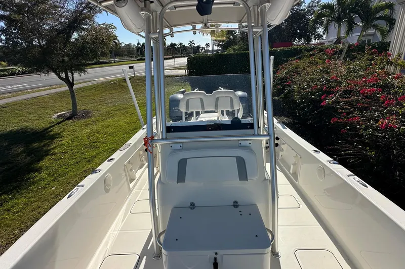 Slide: The Image of 2015 Carolina Cat 23CC boat interior with console and seating, parked outdoors. - 12
