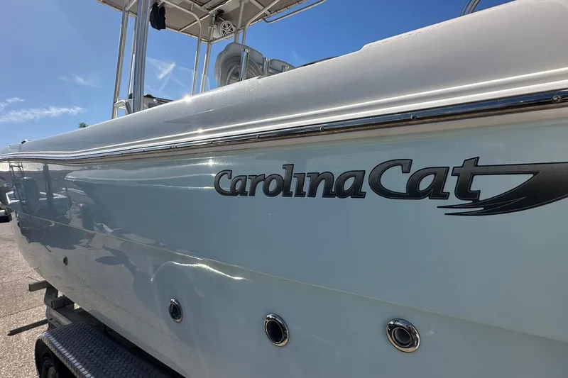 Slide: The Image of 2015 Carolina Cat 23CC boat side view with logo under clear blue sky. - 17
