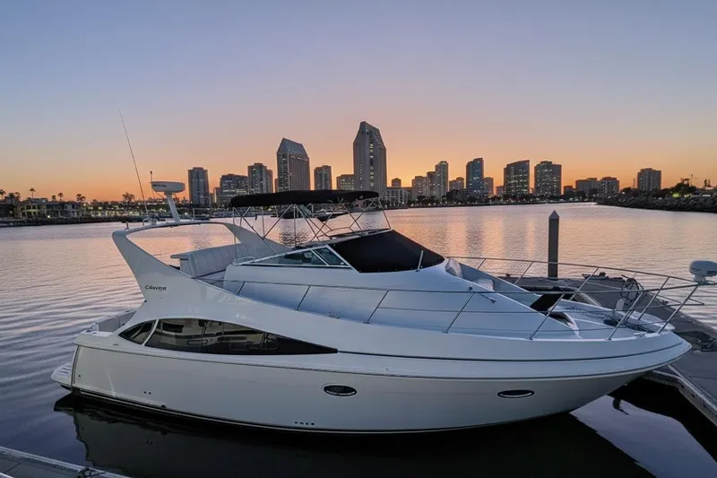 The Image of 2004 Carver 360 Mariner yacht docked at sunset with city skyline backdrop. - 0