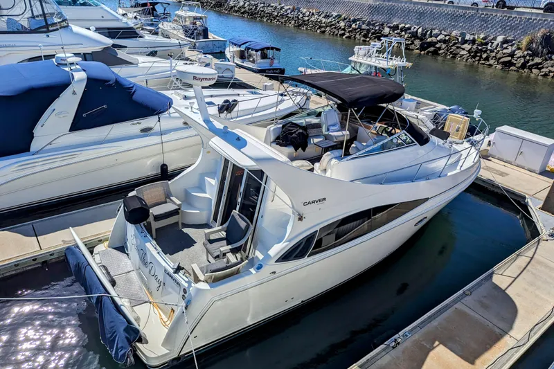 Slide: The Image of 2004 Carver 360 Mariner yacht docked at marina, featuring spacious deck and sleek design. - 10