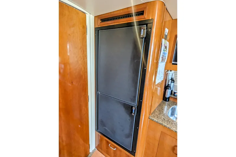 Slide: The Image of 2004 Carver 360 Mariner interior with wooden cabinetry and built-in refrigerator. - 11