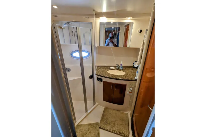 Slide: The Image of 2004 Carver 360 Mariner bathroom with shower, sink, and oval window. - 14