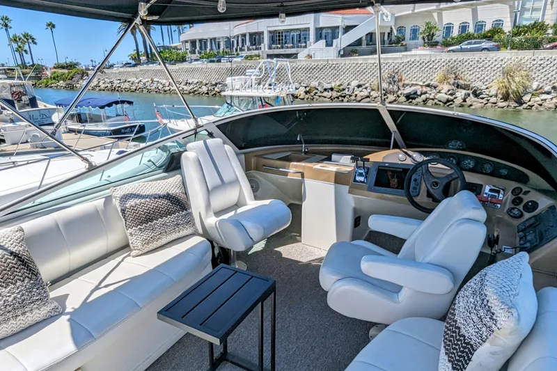 Slide: The Image of 2004 Carver 360 Mariner yacht interior with plush seating and helm, docked in marina. - 2