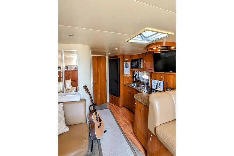 Slide: The Image of Interior of 2004 Carver 360 Mariner yacht with kitchen, seating, and guitar. - 20