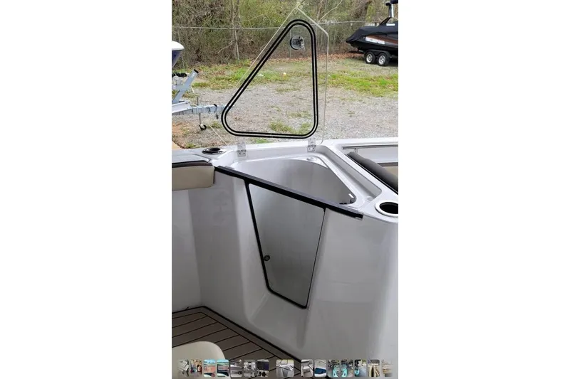 Slide: The Image of 2022 Yamaha Boats 252 FSH Sport interior with open storage compartment and seating area. - 3