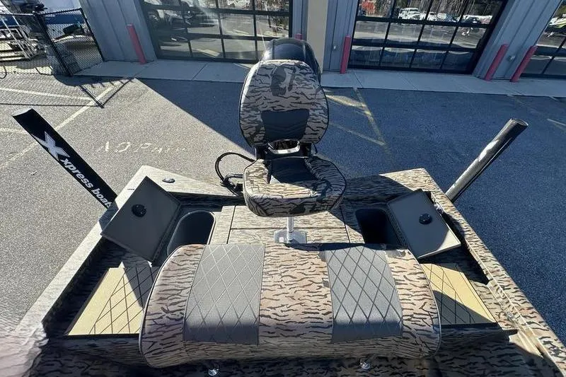 Slide: The Image of 2026 Xpress H190B Bay boat with camo seating and storage compartments. - 10