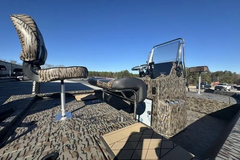 Slide: The Image of 2026 Xpress H190B Bay boat with camo seats and console, under clear blue sky. - 11