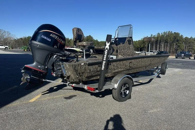 Slide: The Image of 2026 Xpress H190B Bay boat with Yamaha engine on trailer in parking lot. - 2