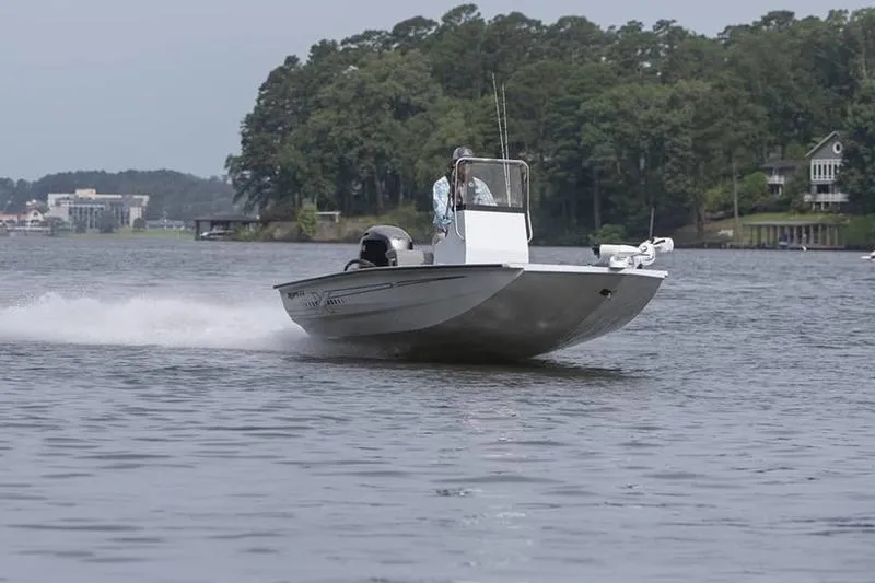 Slide: The Image of 2026 Xpress H190B Bay boat cruising on a scenic lake with lush greenery. - 21