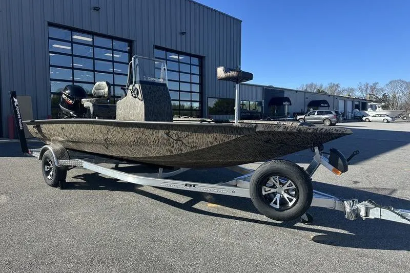 Slide: The Image of 2026 Xpress H190B Bay boat on trailer, parked outside industrial building. - 6