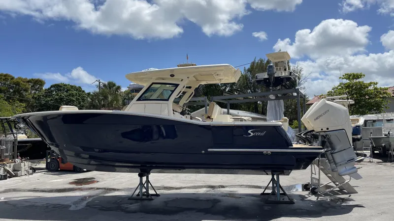 Slide: The Image of Scout 305 LXF 2026 on a boat lift under blue sky. - 10
